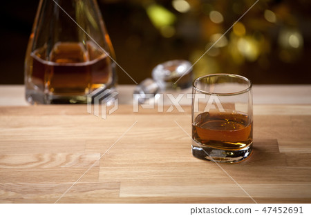 whiskey glass wooden table gold bokeh  47452691