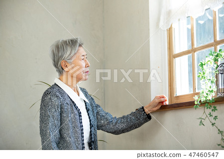 站立在窗口的資深婦女 47460547