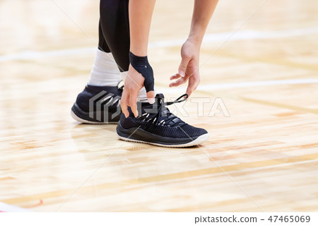 Person who adjusts basketball shoes 47465069