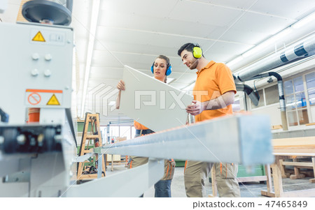 Carpenter in furniture factory inspecting piece in QA Carpenter in furniture factory inspecting piece in QA 47465849