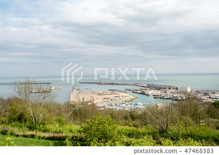 A harbor where warehouses and others seen from the top of Dobber's cliff under the cloudy cloudy sky are lined with a horizontal line that can be seen far away A harbor where warehouses and others seen from the top of Dobber's cliff under the cloudy cloudy sky are lined with a horizontal line that can be seen far away 47468383
