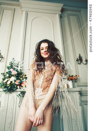young pretty brunette girl in fashion dress on sofa posing in luxury rich home interior, lifestyle 47468948