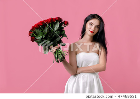 beautiful young woman with a large bouquet of red roses beautiful young woman with a large bouquet of red roses 47469651