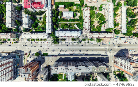 Aerial city view with crossroads and roads, houses, buildings, parks and parking lots. Sunny summer Aerial city view with crossroads and roads, houses, buildings, parks and parking lots. Sunny summer 47469652