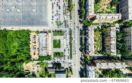 Aerial city view with crossroads and roads, houses, buildings, parks and parking lots. Sunny summer Aerial city view with crossroads and roads, houses, buildings, parks and parking lots. Sunny summer 47469663