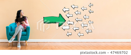 Arrow facing in a opposite direction with woman using a tablet 47469702