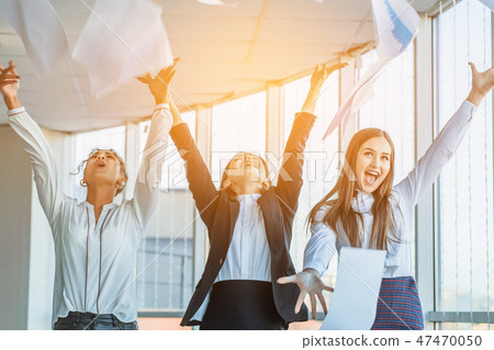 Three young beautiful brunette business ladies in the office. All happy dancing dancing up the Three young beautiful brunette business ladies in the office. All happy dancing dancing up the 47470050