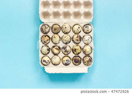 Quail eggs in cardboard box on blue background Quail eggs in cardboard box on blue background 47472926