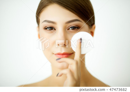 Skincare. Young woman with lotion washing face at bathroom 47473682