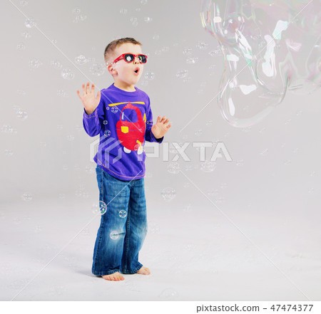 Little man playing with soap bubbles Little man playing with soap bubbles 47474377