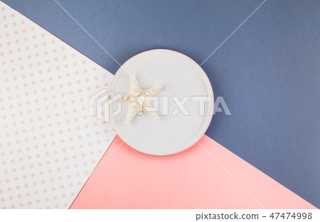 Plate with seashells on color paper background 47474998