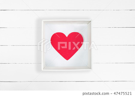 Red paper heart in white cardboard box on white wooden background Red paper heart in white cardboard box on white wooden background 47475521