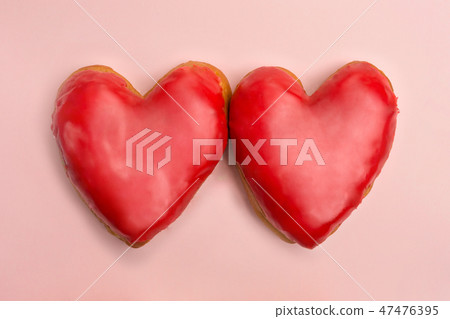 Valentine heart shaped red donuts on pink background Valentine heart shaped red donuts on pink background 47476395