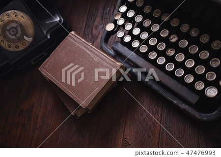 Old retro phone with vintage typewriter and books Old retro phone with vintage typewriter and books 47476993