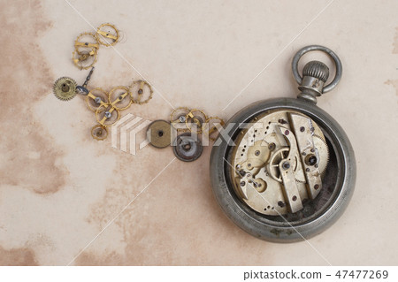 broken pocket watch on dirty paper background broken pocket watch on dirty paper background 47477269