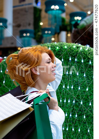 Young Women with Packages Shopping in Modern Mall. Shopping Concept. Black Friday Concept. Happy Young Women with Packages Shopping in Modern Mall. Shopping Concept. Black Friday Concept. Happy 47477620