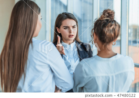Three beautiful young business ladies. Speaks to colleagues with a copy of space on the background Three beautiful young business ladies. Speaks to colleagues with a copy of space on the background 47480122