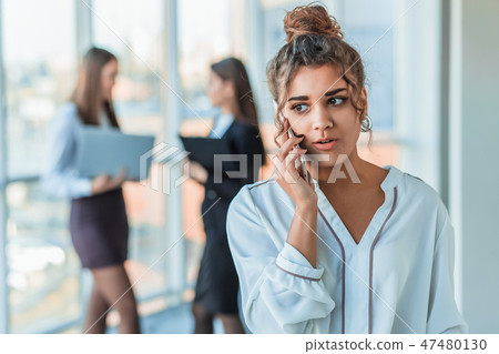 Business lady at the office talking to a smartphone. Happy smiling Caucasian business woman busy Business lady at the office talking to a smartphone. Happy smiling Caucasian business woman busy 47480130