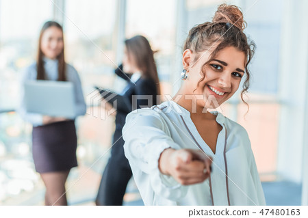 The business lady in the office giving his consent to the signing of a contract stretches out his The business lady in the office giving his consent to the signing of a contract stretches out his 47480163