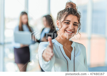 The business lady in the office giving his consent to the signing of a contract stretches out his The business lady in the office giving his consent to the signing of a contract stretches out his 47480167