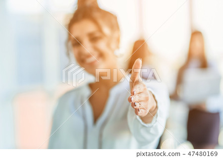The business lady in the office giving his consent to the signing of a contract stretches out his The business lady in the office giving his consent to the signing of a contract stretches out his 47480169