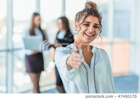 The business lady in the office giving his consent to the signing of a contract stretches out his The business lady in the office giving his consent to the signing of a contract stretches out his 47480170