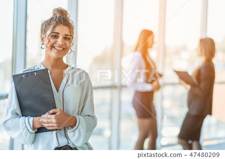 Business lady at the office talking to a smartphone. Happy smiling Caucasian business woman busy Business lady at the office talking to a smartphone. Happy smiling Caucasian business woman busy 47480209