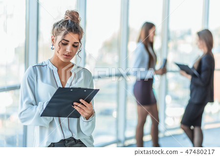 Business lady at the office talking to a smartphone. Happy smiling Caucasian business woman busy Business lady at the office talking to a smartphone. Happy smiling Caucasian business woman busy 47480217