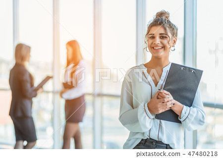 Business lady at the office talking to a smartphone. Happy smiling Caucasian business woman busy Business lady at the office talking to a smartphone. Happy smiling Caucasian business woman busy 47480218