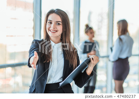 Beautiful brunette business woman in a white suit from a folder of documents in hand outdoors. copy Beautiful brunette business woman in a white suit from a folder of documents in hand outdoors. copy 47480237