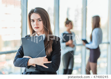 Beautiful brunette business woman in white suit with folder of documents in her hands outdoors. copy Beautiful brunette business woman in white suit with folder of documents in her hands outdoors. copy 47480245