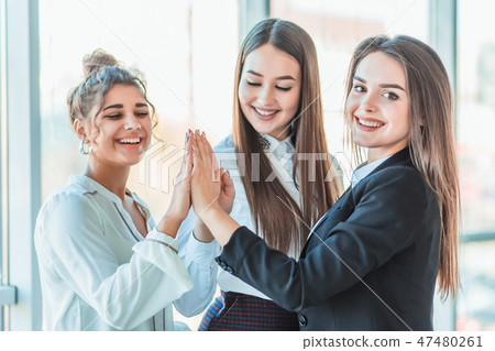 Power of friendship in business company. Three attractive happy smiling joyful smart professional Power of friendship in business company. Three attractive happy smiling joyful smart professional 47480261