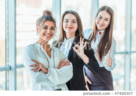 Young pretty business girls show a good gesture. Dressed in classic clothes Young pretty business girls show a good gesture. Dressed in classic clothes 47480307