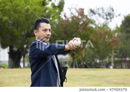 Businessman holding baseball ball Businessman holding baseball ball 47489379