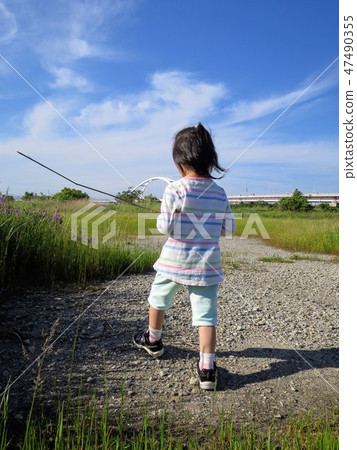 一個小孩在玩一根棍子 47490355