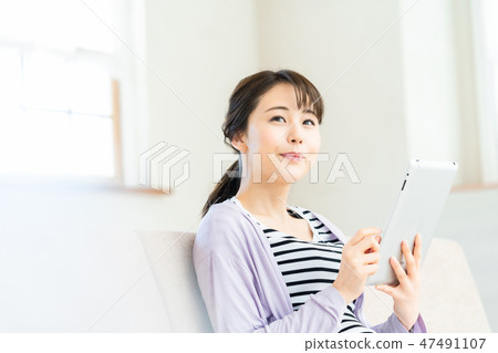 Young woman looking at tablet internet girl lifestyle female portrait Young woman looking at tablet internet girl lifestyle female portrait 47491107