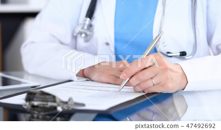 Female doctor filling up medical form on a clipboard, closeup. Healthcare, insurance and medicine 47492692