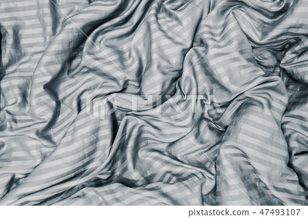 blanket wrinkled on the bed in bedroom. 47493107