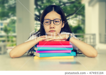 Woman tired student girl with glasses and books on desk, Bored a Woman tired student girl with glasses and books on desk, Bored a 47493184