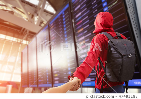 Young man Man holding hand of wife following himwith backpack an Young man Man holding hand of wife following himwith backpack an 47493185