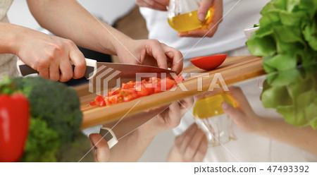 Closeup of human hands cooking in kitchen. Mother and daughter or two female friends cutting Closeup of human hands cooking in kitchen. Mother and daughter or two female friends cutting 47493392
