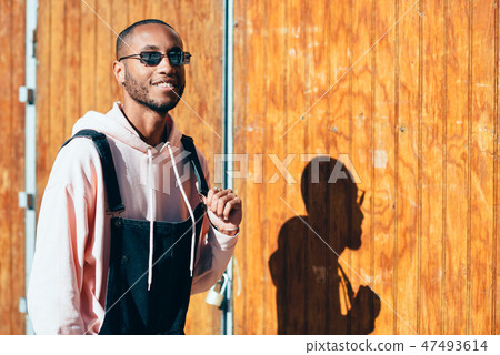 Young black man wearing casual clothes and sunglasses outdoors 47493614