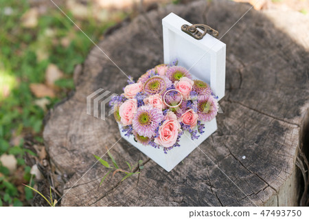 casket with wedding rings and fresh flowers for ceremony 47493750