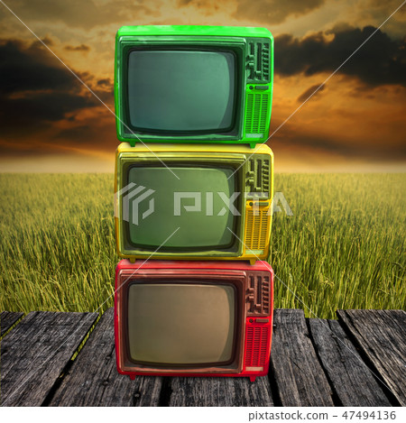 Retro television on wooden deck with farmland  47494136
