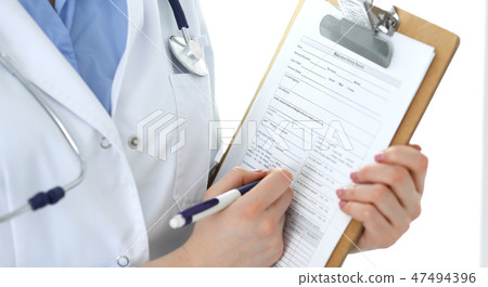 Female doctor using medical form on clipboard closeup. Physicianat work in hospital or clinic Female doctor using medical form on clipboard closeup. Physicianat work in hospital or clinic 47494396