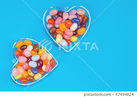 Two hearts with candies on blue background 47494624
