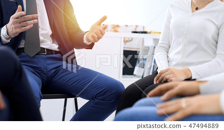 Group of people sitting in a circle during therapy. Meeting of business team participating in 47494889