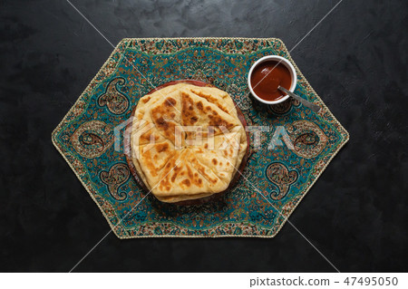 Arabic Cheese Bread with red sauce on black table 47495050