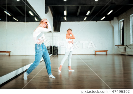 Red-haired ballet teacher and her student practicing new dance 47496302