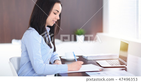 Young brunette business woman looks like a student girl working in office. Hispanic or latin 47496353